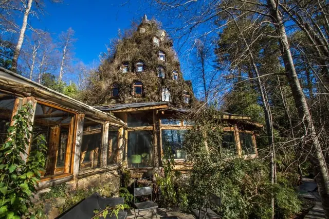 Edificio de Montaña Mágica cubierto de vegetación bajo un cielo despejado