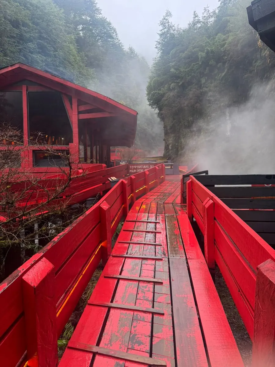 Pasarela roja entre piscinas y vapor de agua